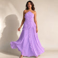 Modelka w fioletowej sukience maxi halter z plisowanymi falbanami asymetrycznymi, wieczorowy look