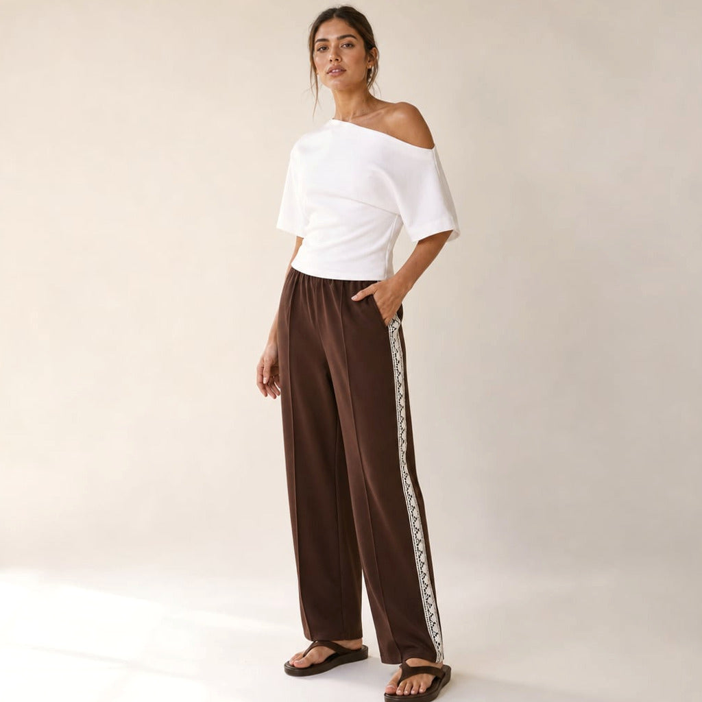 Modelka w prostych spodniach z lampassem w kolorze Chocolate, koronkowy detal na kostce, stylizacja casualowa